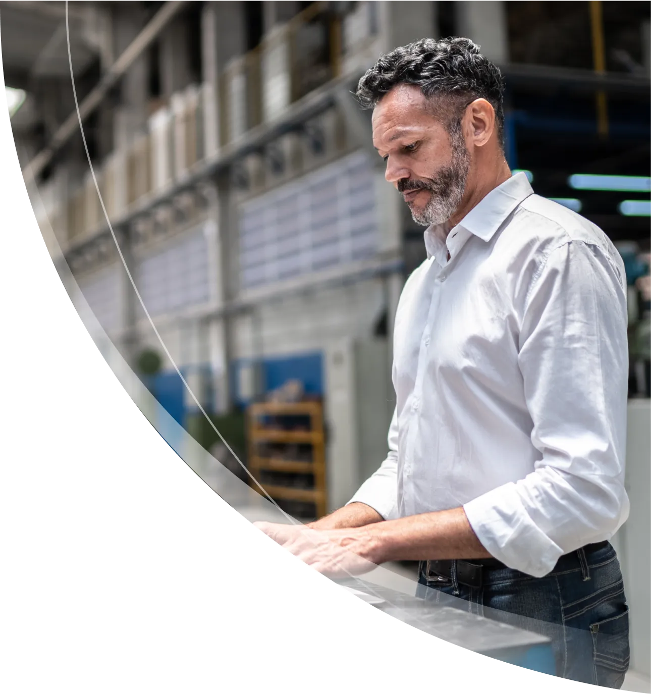 Middle-aged man in a factory using a digital tablet, wearing a white shirt